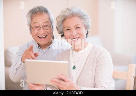 Elderly couple using a tablet computer at home Stock Photo