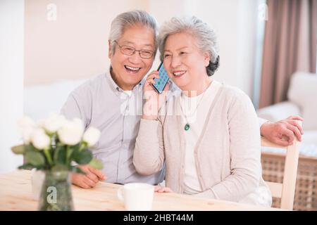 Elderly couple calling at home Stock Photo