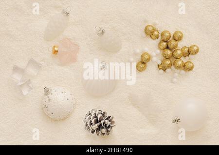 Pastel New Year's concept. Lots of puffy snow. Pastel color decorations. Christmas balls are milky white, silver, gold glitter, and pastel pink. Balls Stock Photo