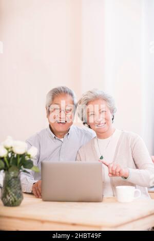 Elderly couple using a laptop at home Stock Photo
