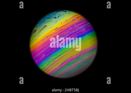 Abstract multicolor psychedelic planet. Closeup Soap bubble like an alien planet on dark background Stock Photo