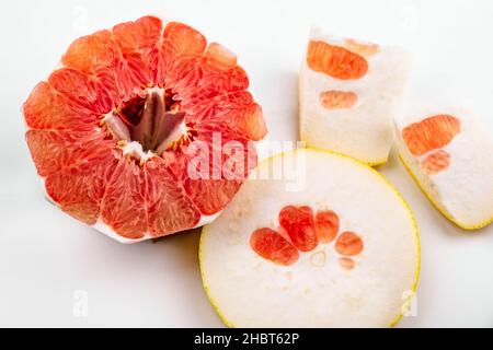 Sliced red grapefruit, texture of flesh, circle of peel on white background, closeup. Stock Photo