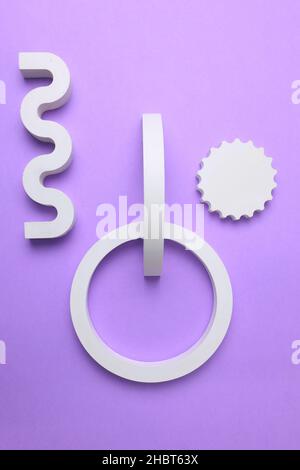 Abstract background of plaster geometric shapes. Circle and wave top view. White figures from plaster on a lilac background. Stock Photo