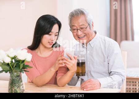 Daughter and father using a smart phone Stock Photo
