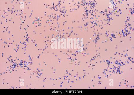 Pink background with small purple holographic sparkles. Trendy colors 2022. Beautiful backdrop for valentines day, christmas, birthday. Stock Photo