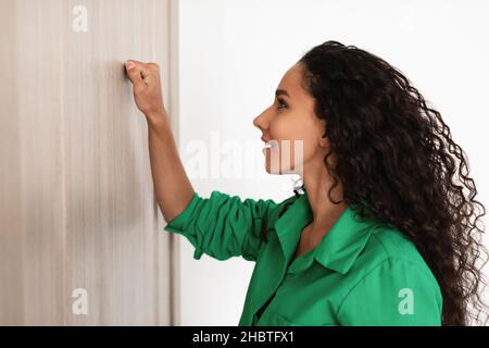 Closeup of lady knocking on the wooden door Stock Photo