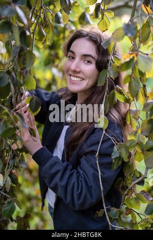 Teenage Woman Standing Surrounded by Trees Stock Photo