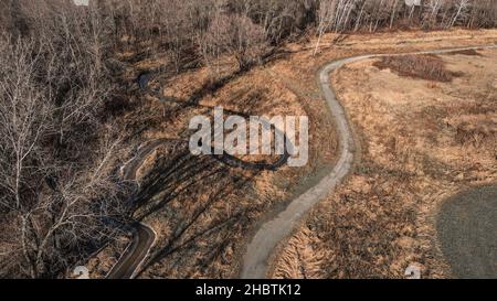 Hiking trail with stream alongside it in autumn woods Stock Photo