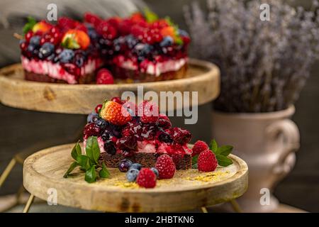 Chocolate cake with berries on top, triangle slice cake, close up Stock Photo