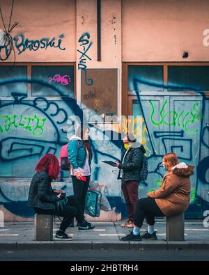 BUCHAREST, ROMANIA - Oct 19, 2021: A group of girls friends gossiping in the streets at the bus stop in Bucharest Romania Stock Photo