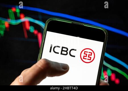 China. 09th Dec, 2021. In this photo illustration the Chinese multinational banking company and largest bank in the world Industrial and Commercial Bank of China (ICBC) logo seen displayed on a smartphone with an economic stock exchange index graph in the background. Credit: SOPA Images Limited/Alamy Live News Stock Photo