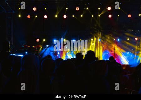 Concert background. Spotlights on the stage and silhouette of people in concert Stock Photo