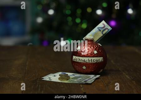 Christmas money in a piggy bank in the form of a Christmas tree toy. Stock Photo