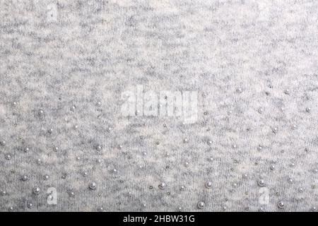 Knitted background. Light gray gentle wool background pattern. Background embroidered with beads Stock Photo