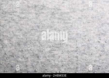 Knitted background. Light gray gentle wool background pattern. Background embroidered with beads Stock Photo