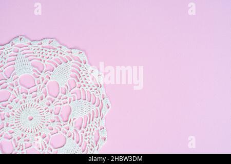 A white crochet embroidered doily on a blue surface Stock Photo