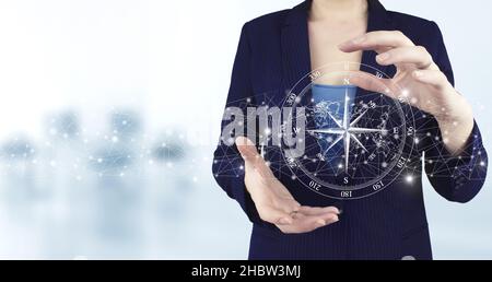 Navigation concept. Map and innovation concept. Two hand holding virtual holographic compass icon with light blurred background. The compass navigate Stock Photo