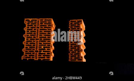 Close up of two red bricks moving against black background, construction and materials concept. New bricks isolated on black background. Stock Photo