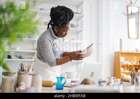 Woman pottery artist working in her art studio Stock Photo