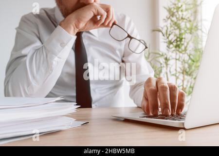 Business decision-making mistakes, businessman realizing wrong steps he had made while sitting at the office desk and using laptop, selective focus Stock Photo