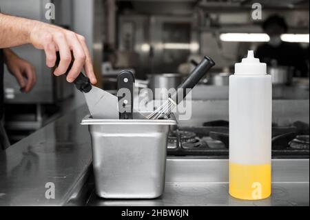 Close up of a chef using a spatula at a commercial kitchen. High quality photo Stock Photo