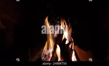 Closeup firewood burns in the fireplace in the evening. Stock Photo
