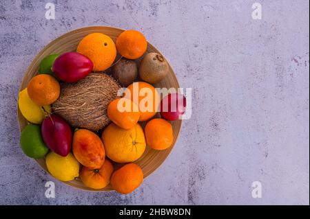 Citrus fruits on gray concrete pattern. Assorted citrus fruits and tamarillo. Coco on vintage table and other fruits. Copy space for your text. Sweet Stock Photo