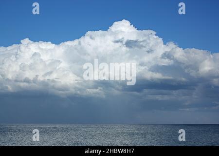 The origin of the storm is far out at sea. A huge white cloud over the dark sea. High quality photo Stock Photo