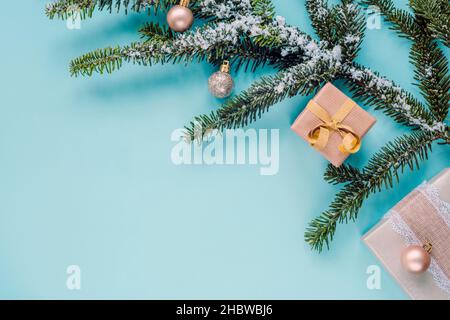 Christmas festive background. Spruce branch, Christmas decorations and gifts in boxes on teal blue backdrop. Top view, flat lay, copy space Stock Photo