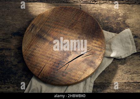 round wooden cutting board on rustic kitchen table, top view Stock Photo