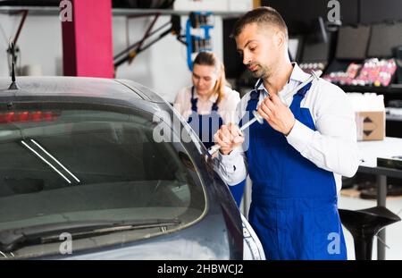 Mechanic performing dent repair Stock Photo