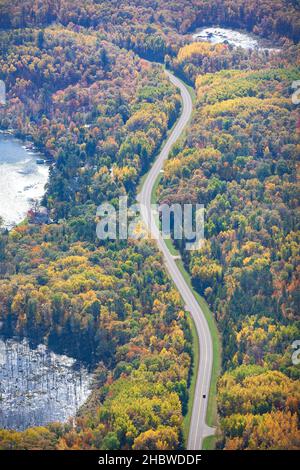 Aerial view of curving road and lakes and trees in northern Minnesota on a sunny autumn day Stock Photo
