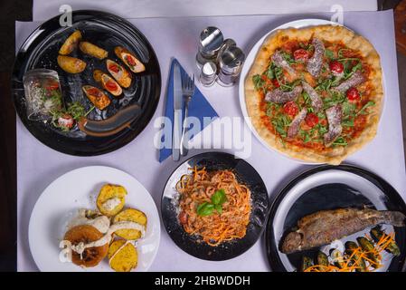 A top view of different dishes on a white table Stock Photo