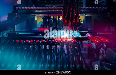 Installation of electronic components on printed circuit board: technology of automated microchip production and computer components. Production of electronic chips and boards on automatic SMT machine Stock Photo