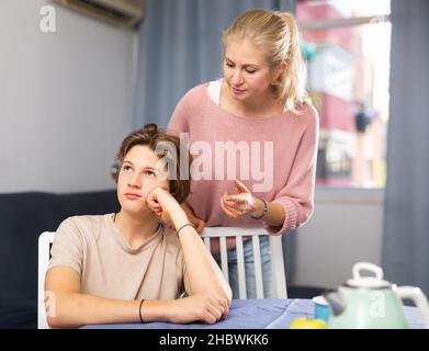 Portrait Of Upset Teen Boy In Sportswear Scolded By Mother At