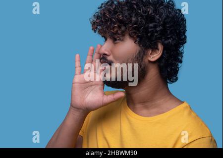 Focused good-looking young Indian man calling someone Stock Photo