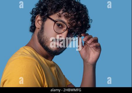 Serious man in round eyeglasses looking ahead Stock Photo