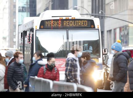 New York, United States. 21st Dec, 2021. A masks required digital sign hangs above the windshield of an MTA bus as pedestrians cross Fifth Avenue in New York City on Tuesday, December 21, 2021. New York continues to set records for positive COVID cases as holiday travel ramps up. Photo by John Angelillo/UPI Credit: UPI/Alamy Live News Stock Photo