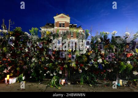 MAYFIELD, KENTUCKY - DECEMBER 20:  Flowers and photos of those who died are left at a makeshift memorial on a fence surrounding the Graves County courthouse, on December 20, 2021 in Mayfield, Kentucky.  Multiple nighttime tornadoes struck several Midwest states on December 10, causing widespread destruction and multiple casualties. Stock Photo