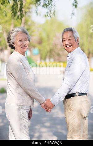 Happy old couple walking in the park Stock Photo