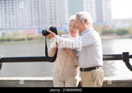 Elderly couple taking pictures with a digital camera Stock Photo