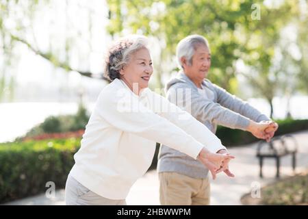 Elderly couple exercising in the park Stock Photo