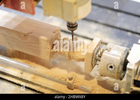 Workpiece processing on CNC wood turning lathe machine. Selective focus. Stock Photo