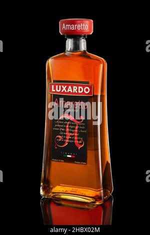 Tel Aviv, Israel - December 20, 2021: Italian liqueur Amaretto on black background with reflection. Stock Photo