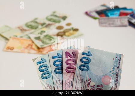 Holding five hundreds Turkish Banknotes aganist blurred money and cards.Conceptual image of business and finance. Stock Photo