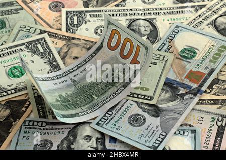 Back Side Of Hundred American Dollar curled up on other banknotes. Stock Photo