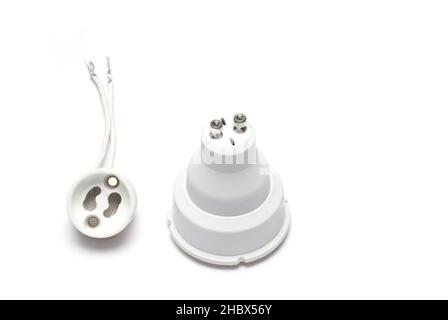 Close up of GU10 lamp socket with matching LED lamp bulb next to it isolated on white background Stock Photo