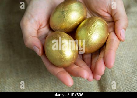 Woman hands holding golden egg Stock Photo