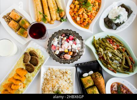 Traditional Turkish dinner table bayram sofrasi End of Ramadan Feast or Sacrifice Feast.Designed festive foods around of copper candy bowl.Top view Stock Photo