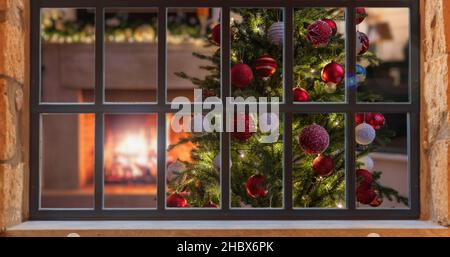 Christmas window. Xmas tree decoration, burning fireplace, winter holiday home interior, view from outdoors Stock Photo